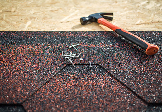 Nails and hammer on roof for roof repair in Kent, WA